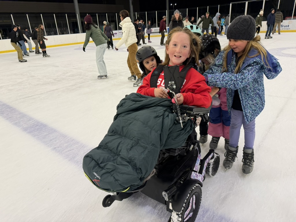 Bella on the ice rink surrounded by friends