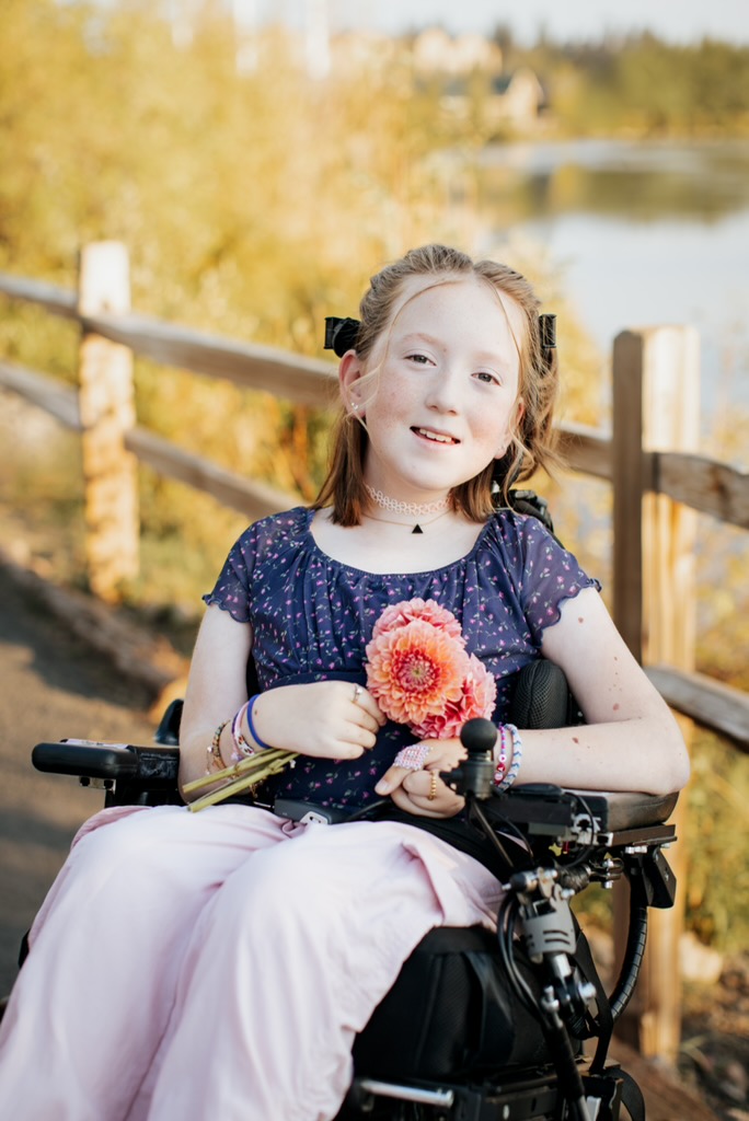 Bella outdoors holding a beautiful flower at golden hour