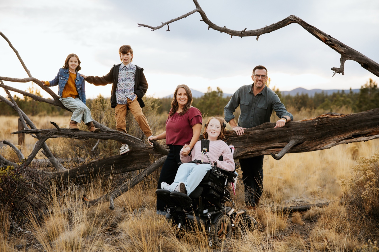 The Beare family gathered around a fallen log at golden hour
