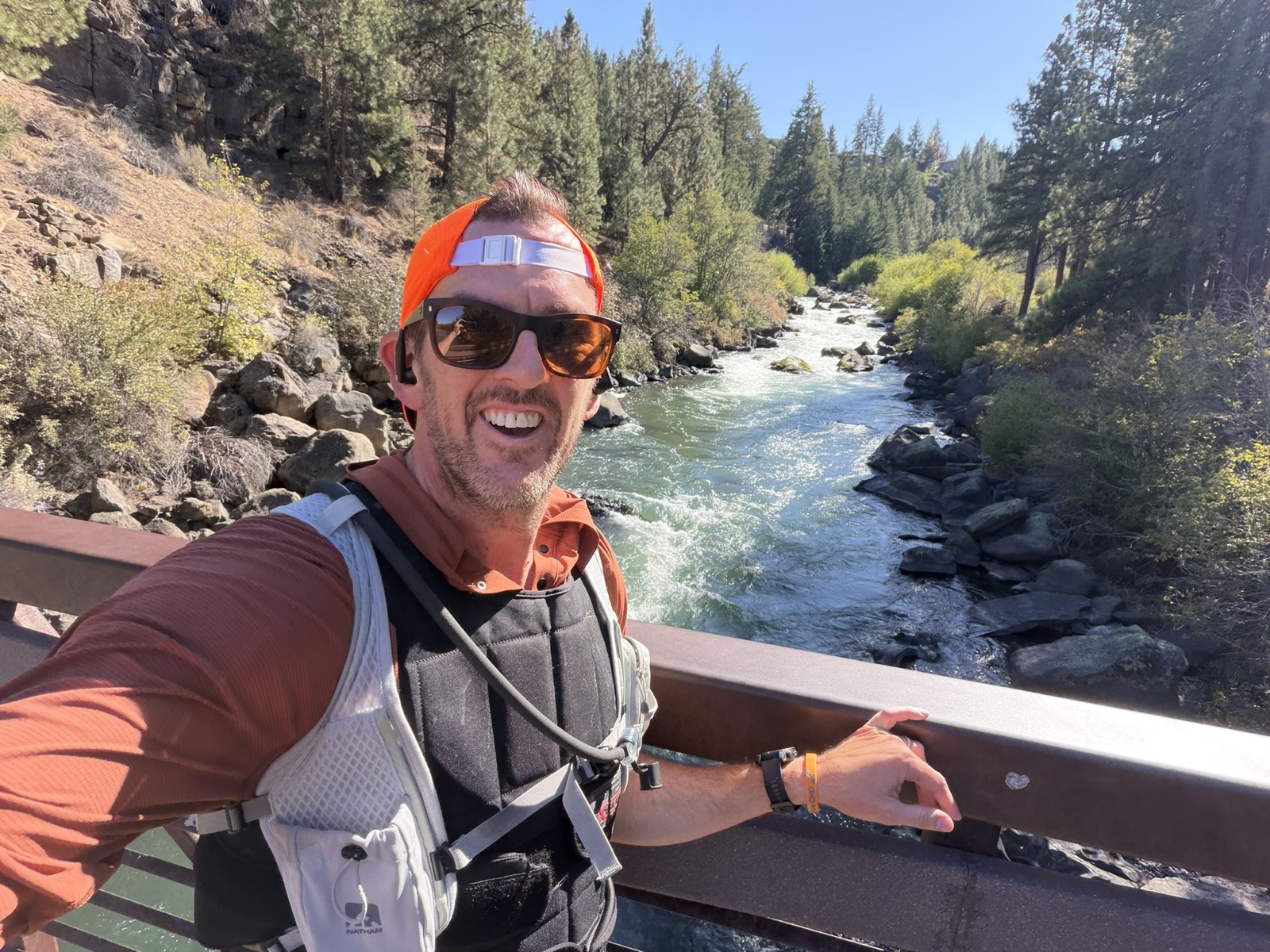 Mark smiling on a trail run beside a river, wearing his weighted running vest